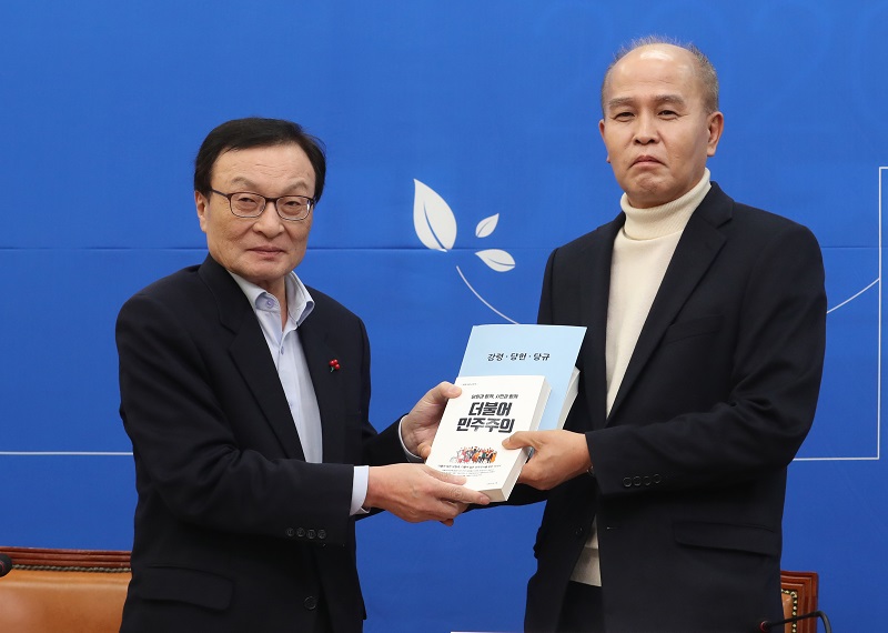 이해찬 더불어민주당 대표가 지난 달 서울 여의도 국회 더불어민주당 회의실에서 일곱번째 총선 인재영입인사인 이용우 카카오뱅크 대표이사에게 당헌 당규 책자를 증정하고 있다. 자료사진.