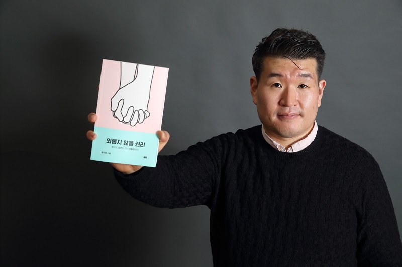 황두영 보좌관이 자신이 집필한 책 '외롭지 않을 권리'를 들고 있는 모습. 자료사진.