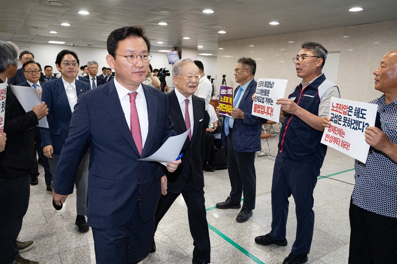 손경식 한국경영자총협회 회장을 비롯한 경제6단체 대표들이 18일 서울 여의도 국회 소통관에서 열린 노조법 개정안 수정 촉구 기자회견에 들어서는 가운데 노조법 2·3조 개정 운동본부 관계자들이 노조법 개정을 촉구하는 손팻말을 들고 있다. 2025.8.18