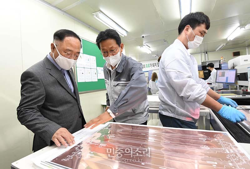 홍남기 부총리 겸 기획재정부 장관이 30일 수출 중소기업에 방문해 관계자의 설명을 듣고 있다.
