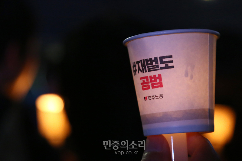 12일 서울 광화문광장에서 열린 ‘박근혜 퇴진! 민중총궐기대회’에서 시민들이 박근혜 비선실세의 국정농단 사태에 재벌도 공범이라고 쓴 종이컵에 촛불을 들고 있다. 2016.1.12