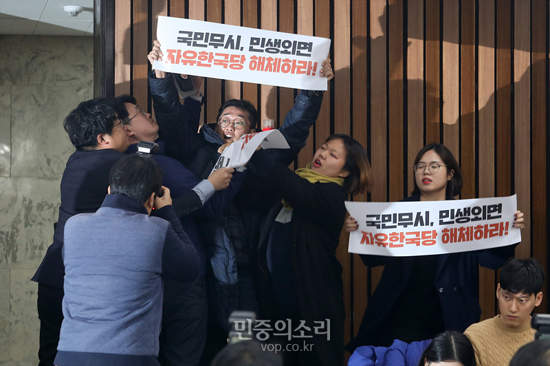 대학생들이 3일 자유한국당 원내대책회의가 열리는 국회 회의실에 진입해 ‘한국당을 해체하라’라고 적힌 손피켓을 들고 시위하고 있다. 2019.12.03