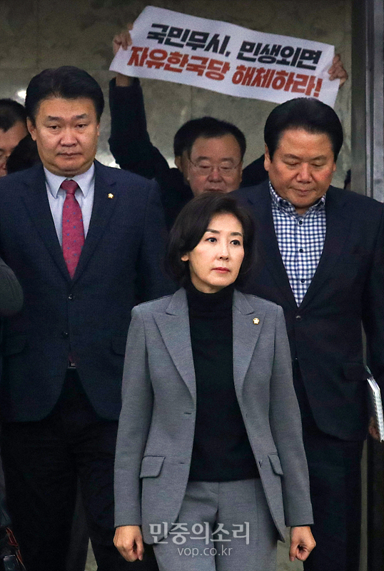 3일 국회에서 자유한국당 나경원 원내대표가 원내대책회의에 참석하는 가운데 대학생이 ‘한국당을 해체하라’라는 손피켓을 들고 시위하고 있다. 2019.12.03