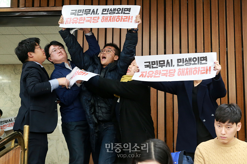 대학생들이 3일 자유한국당 원내대책회의가 열리는 국회 회의실에 진입해 ‘한국당을 해체하라’라고 적힌 손피켓을 들고 시위하고 있다. 2019.12.03