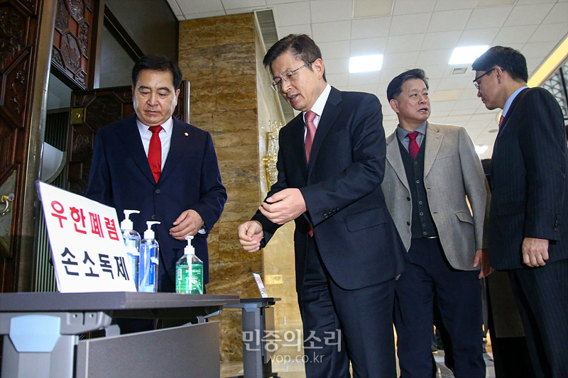 자유한국당 황교안 대표와 심재철 원내대표가 30일 국회에서 열린 의원총회에 참석하며 입구에 설치된 손 소독제를 사용하고 있다. 2020.01.30