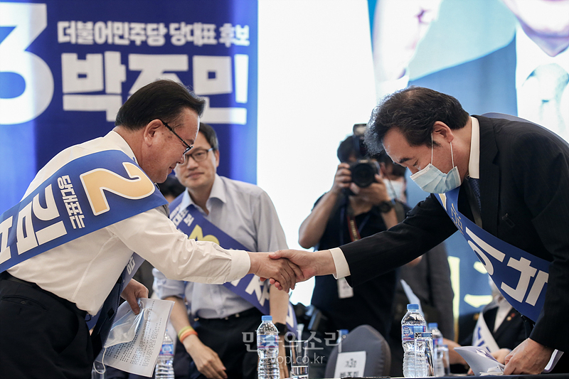 지난 26일 강원도 춘천시 춘천세종호텔에서 열린 더불어민주당 당대표 및 최고위원 후보자 순회합동연설회에서 당대표에 도전하는 김부겸 후보(왼쪽)와 이낙연 후보가 악수하고 있다. 2020.07.26