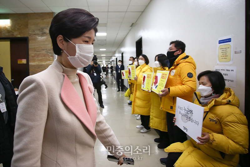 백혜련 법사위 법안심사제1소위원회 위원장(왼쪽)이 지난 7일 국회에서 중대재해기업처벌법을 후퇴한 내용으로 합의한 더불어민주당과 국민의힘을 규탄하는 정의당 의원들 앞으로 지나가고 있다. 2021.01.07