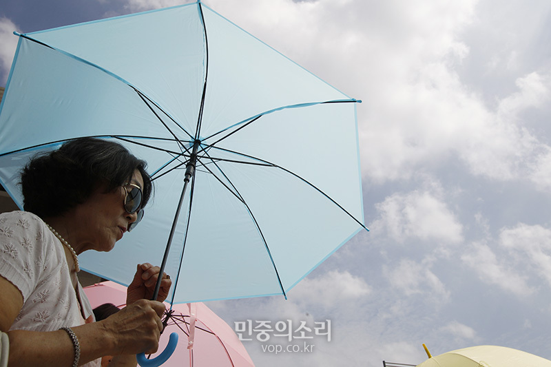 서울 최고기온이 34도 전국적으로 폭염이 이어지는 가운데 서울 세종로 광화문광장 주변에서 시민이 우산을 들고 있다. (자료사진)