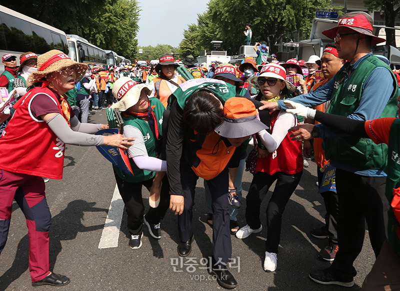 한국도로공사 용역업체 소속으로 고속도로 톨게이트에서 요금수납 업무를 하다 집단해고당한 노동자들이 1일 오후 청와대 인근에서 도로공사 직접고용 등을 촉구하는 집회를 마친 뒤 청와대로 향하다 경찰에 막혔다. 경찰과 대치하던 중 한 노동자가 쓰러져 업혀 나오고 있다. 2019.07.01