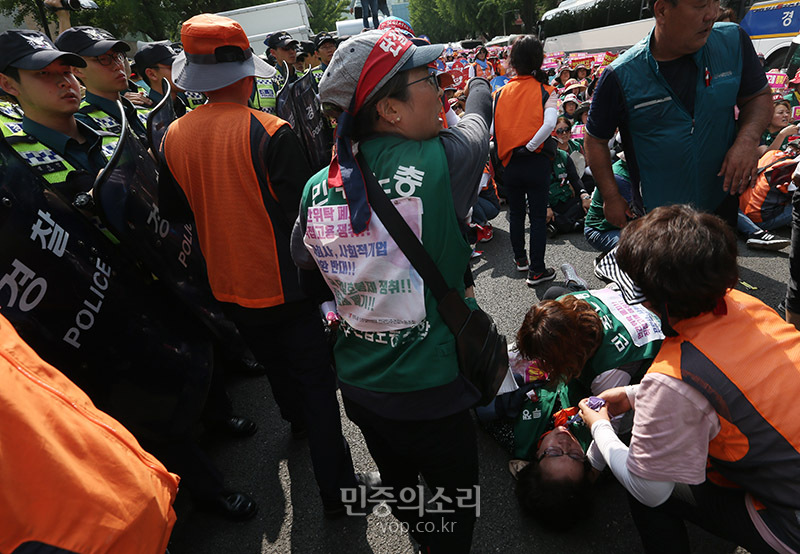 한국도로공사 용역업체 소속으로 고속도로 톨게이트에서 요금수납 업무를 하다 집단해고당한 노동자들이 1일 오후 청와대 인근에서 도로공사 직접고용 등을 촉구하는 집회를 마친 뒤 청와대로 향하다 경찰에 막혔다. 한 노동자가 경찰과 대치 중 쓰러져 있다. 2019.07.01