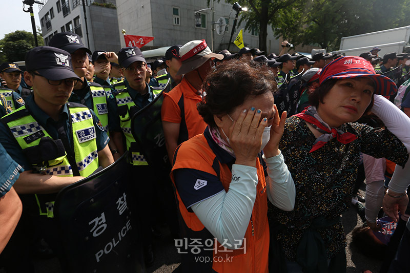 한국도로공사 용역업체 소속으로 고속도로 톨게이트에서 요금수납 업무를 하다 집단해고당한 노동자들이 1일 오후 청와대 인근에서 도로공사 직접고용 등을 촉구하는 집회를 마친 뒤 청와대로 향하다 경찰에 막혀 동료들이 쓰러지자 한 노동자가 눈물을 흘리고 있다.