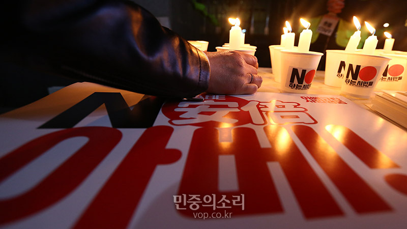 16일 저녁 서울 종로구 옛 주한일본대사관 앞 소녀상 앞에서 아베규탄 시민행동 주최로 열린 ‘아베규탄 친일적폐청산 10차 촛불문화제’에서 한 참석자가 지소미아 완전종료 아베규탄 촛불을 챙기고 있다.  2019.11.16