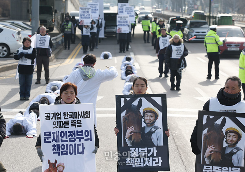 17일 오전 경기도 과천시 한국마사회 앞에서 고 문중원 기수 죽음의 진상규명과 책임자 처벌을 위한 시민대책위원회와 문 기수 유족, 시민사회단체 및 민주노총 등 참석자들이 설 전 문제 해결을 촉구하며 오체투지 행진을 하고 있다.<br