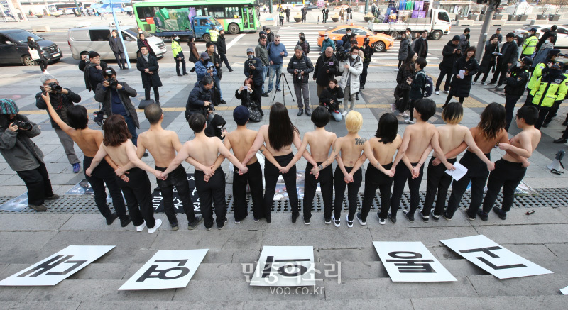 디엑트 액션 에브리웨어(DxE, 직접행동 어디서나) 활동가들이 14일 오후 서울 광화문 세종문화회관 계단에서 착유당하는 동물을 위한 ‘피로 물든 가슴’ 상의 탈의 퍼포먼스을 펼치고 있다. 이들은 발렌타인데이를 타겟으로 초콜렛을 포함한 각종 제품에 쓰이는 유제품의 포장지 속에 감추어진 착유당하는 동물들의 끔찍한 현실을 직접 가시화 했다고 밝혔다. 2020.2.14