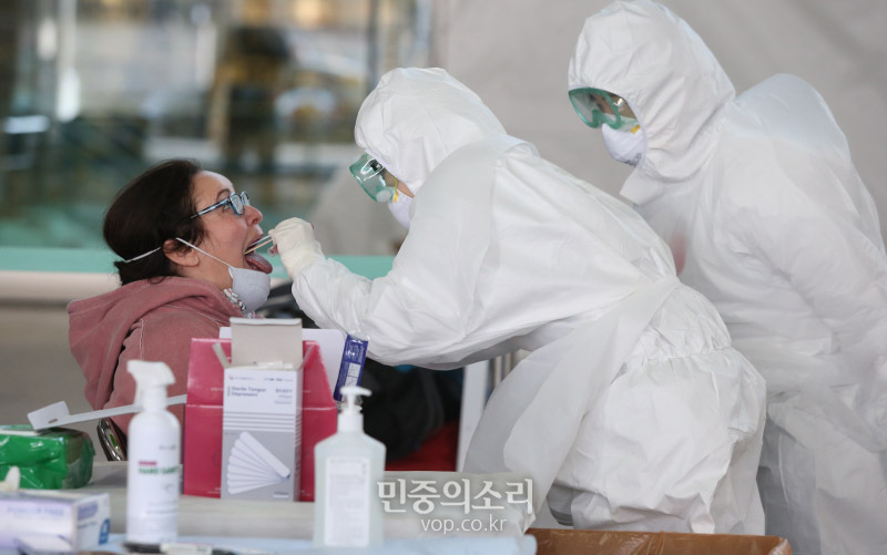 27일 오후 인천국제공항 2터미널 입국장에서 코로나19 외국 유입 차단을 위해 옥외공간에 설치된 개방형 선별진료소(오픈 워킹스루형·Open Walking Thru)에서 외국인 입국자가 코로나19 검사를 받고 있다. 2020.03.27
