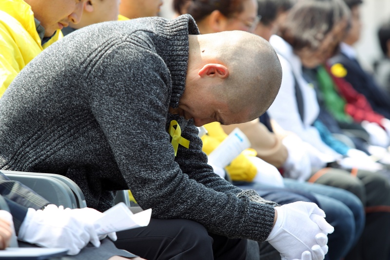 16일 오후 제주항 국제여객선터미널 광장에서 제주도교육청 주관으로 세월호 참사 1주기 추모식이 열리고 있는 가운데 사고 생존자이자 '파란 바지의 의인'으로 불리는 화물기사가 김동수씨가 고개를 숙여 흐느끼고 있다.2015.04.16