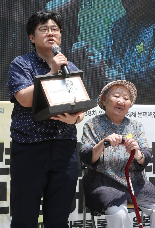 6일 오후 서울 서울 종로구 수송동 구 주한일본대사관 앞에서 제1338차 일본군 성노예제 문제해결을 위한 정기 수요시위에 앞서 열린 제2회 길원옥 여성평화상 시상식에서 수상자 조진경 십대여성인권센터 대표가 수상 소감을 전하고 있다. 오른족은 길원옥 할머니. 2018.06.06.